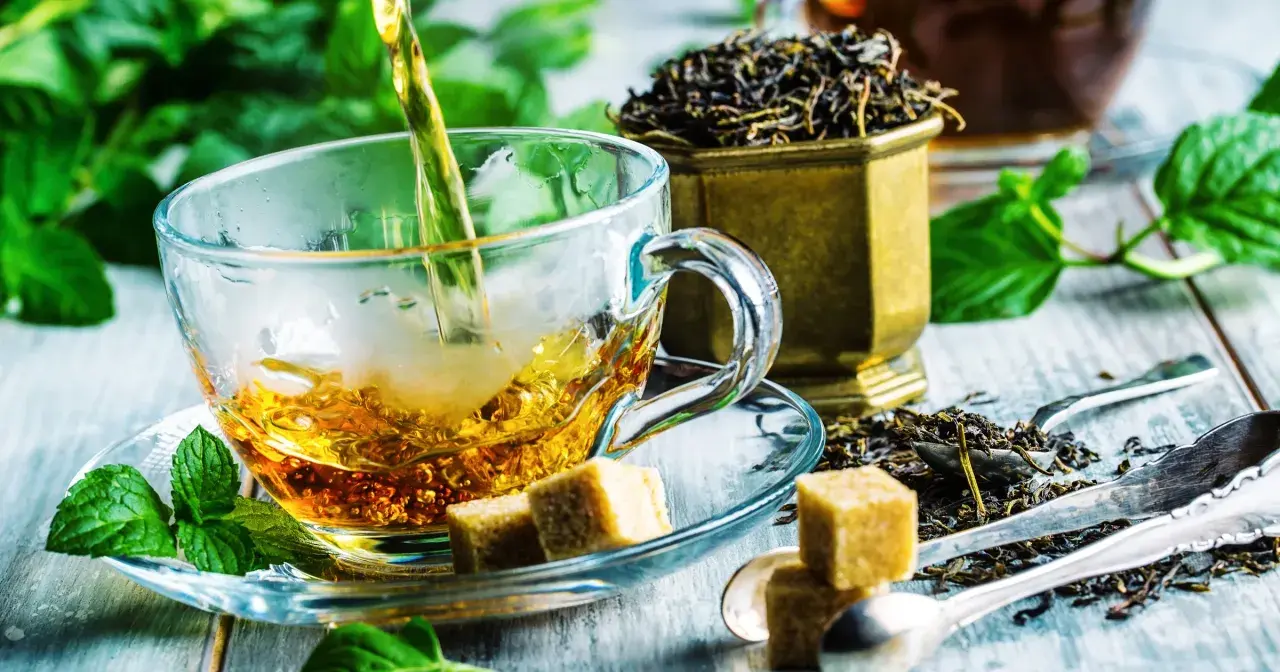 Czy zielona herbata obniża ciśnienie? Zaparzona w szklanej filiżance, z kostkami cukru i świeżą miętą, kusi aromatem.
