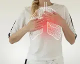 Kobieta trzyma ręce na klatce piersiowej, gdzie widoczny jest zarys płuc z czerwonym obszarem bólu. Ilustracja przedstawia zapalenie opłucnej objawy.