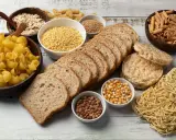 Stół pełen produktów, co ma dużo węglowodanów: makarony, płatki owsiane, chleb, ryż, kasza, kukurydza, soczewica.